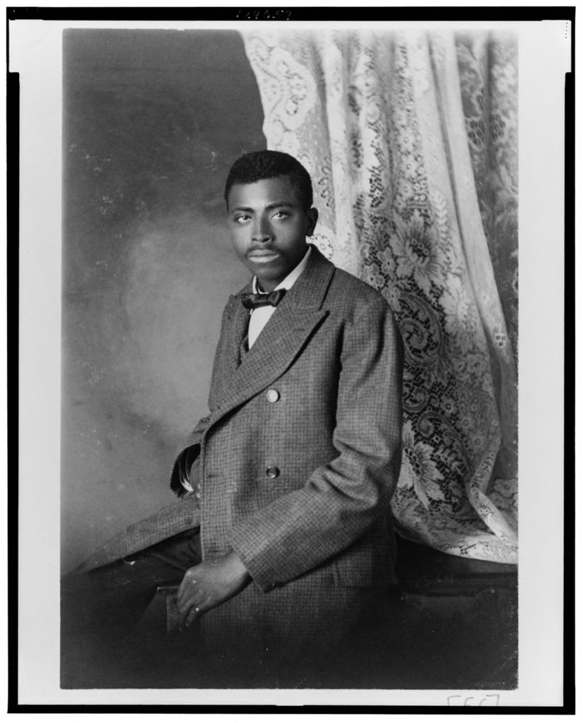 African American man, three-quarter length portrait, seated, facing left