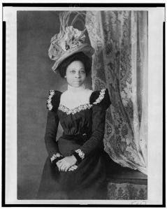 Young African American woman, three-quarter length portrait, facing slightly right, with hands folded on her lap, Attribution to Askew from Photography on the color line